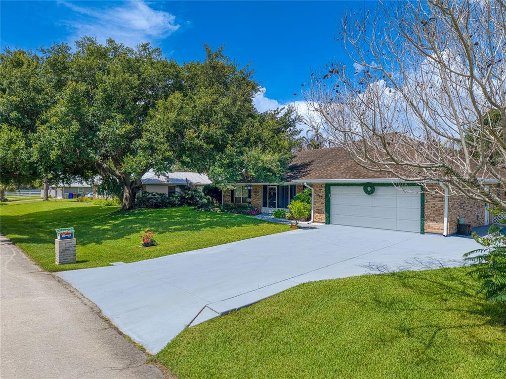 A single-story brick house with a two-car garage and a large tree in the yard — 465 11TH AVENUE, VERO BEACH, FL