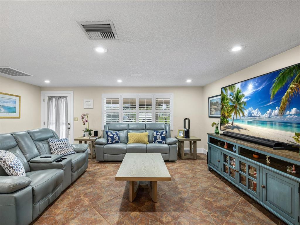 A living room features light blue leather sofas, a wooden coffee table, and tile flooring — 13521 VERONICA DRIVE, HUDSON, FL