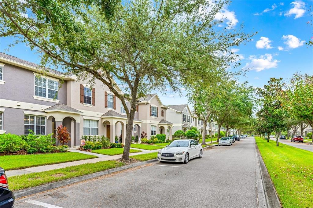 A row of two-story townhomes with beige siding and a white car parked on the street — 12543 CRUXBURY DRIVE, WINDERMERE, FL