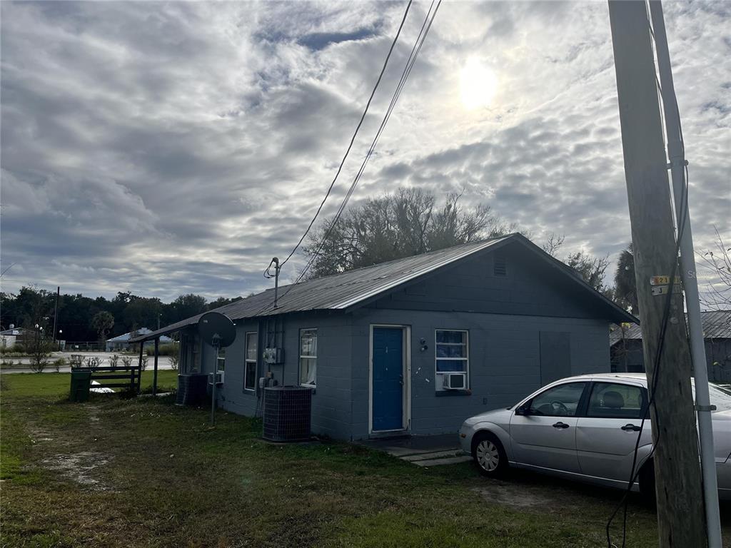 A grey, single-story house with a metal roof and a silver car parked outside — 311 E MAGNOLIA STREET UNIT 2, LEESBURG, FL