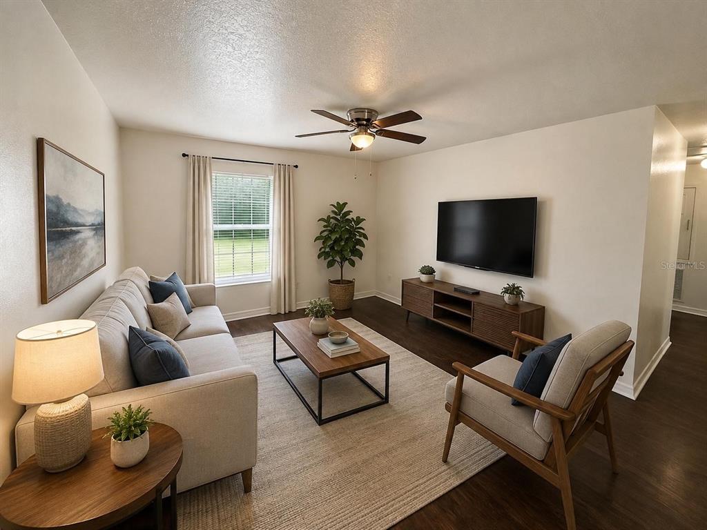 A living room features a sofa, armchair, coffee table, television, and a ceiling fan — 3212 N 50TH STREET UNIT B, TAMPA, FL