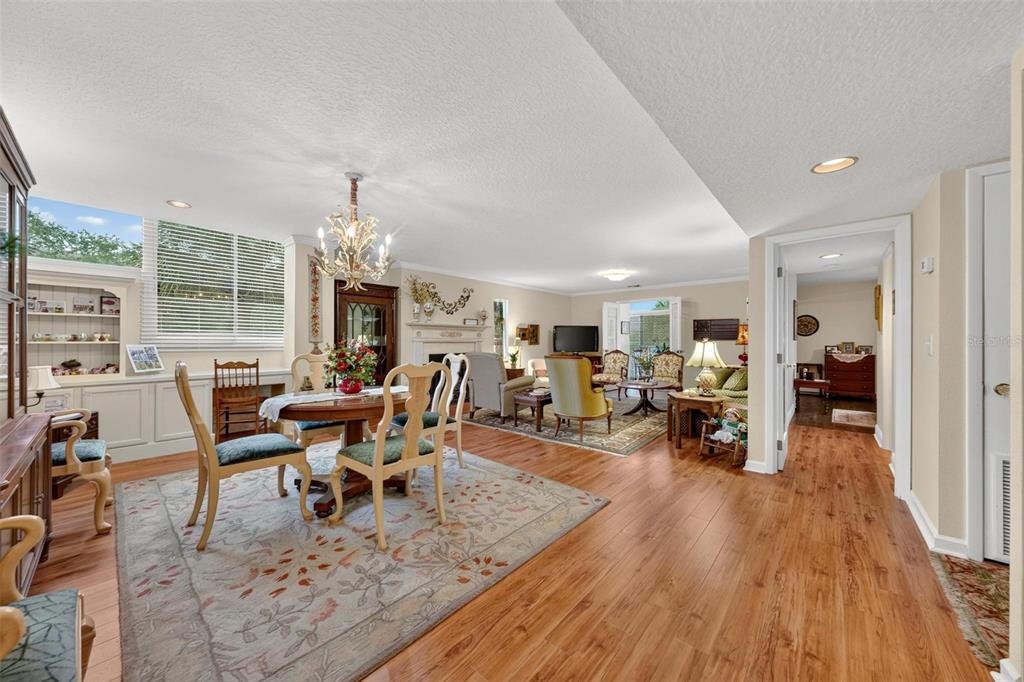 A dining area with a chandelier and rug opens into a living room with hardwood floors — 250 CAROLINA AVENUE UNIT 205, WINTER PARK, FL