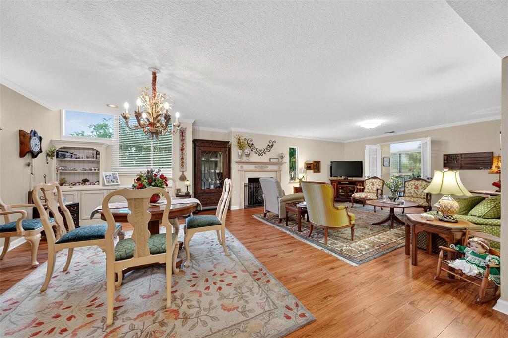 A spacious living and dining area features hardwood floors, a fireplace, and traditional furniture — 250 CAROLINA AVENUE UNIT 205, WINTER PARK, FL