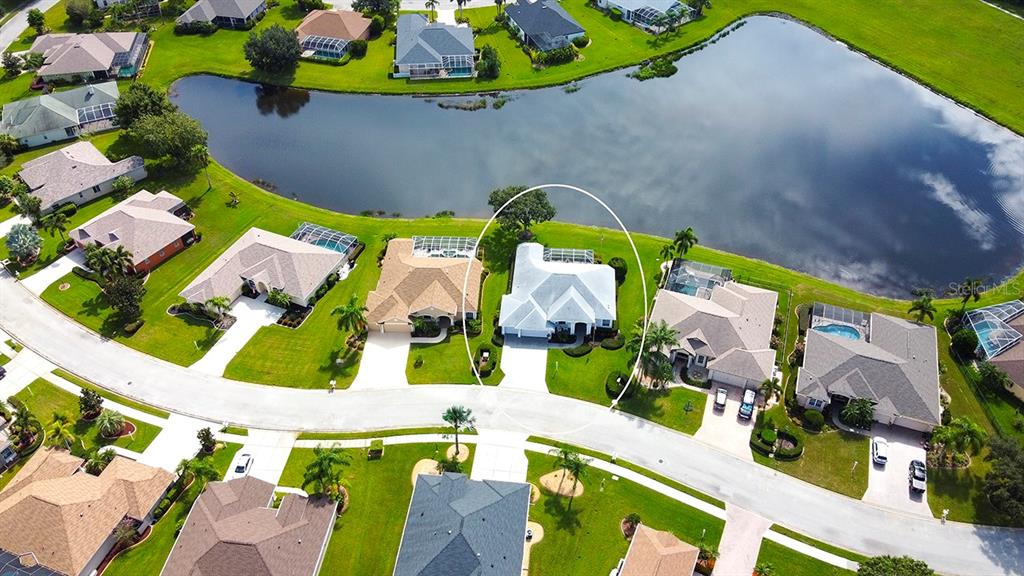 An aerial view shows a residential neighborhood with a white house circled near a lake — 6112 90TH AVENUE CIRCLE E, PARRISH, FL