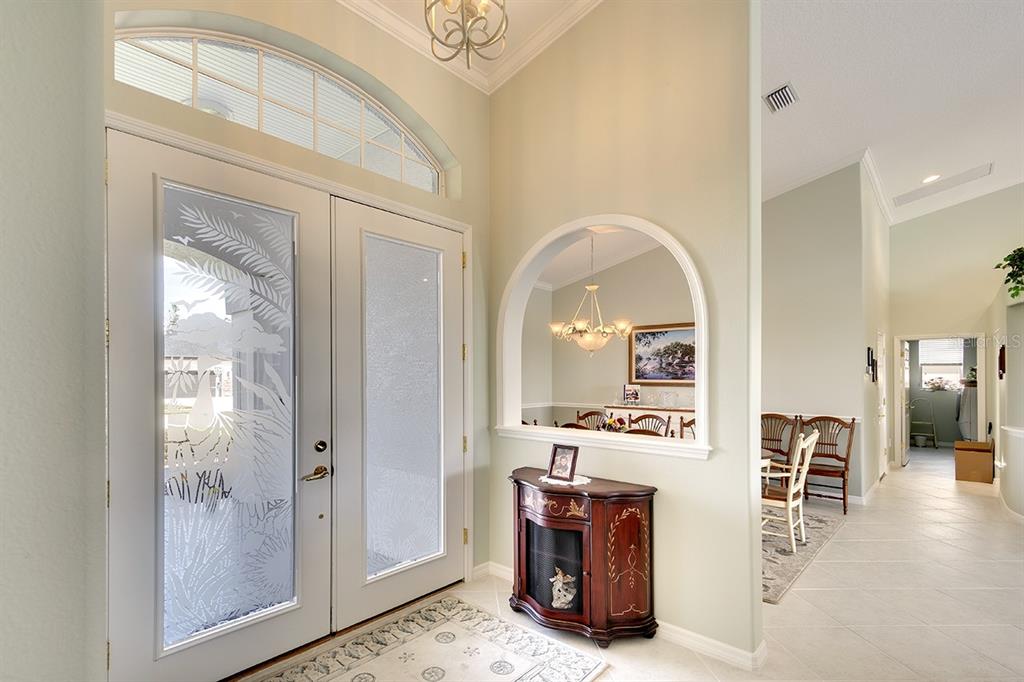 An entryway features double glass doors, a decorative arched niche, and light-colored tile flooring — 6112 90TH AVENUE CIRCLE E, PARRISH, FL