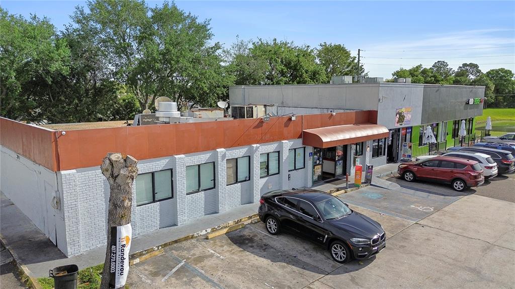 An aerial view of a commercial building with a white brick facade and parking lot — 827 W LANCASTER ROAD, ORLANDO, FL