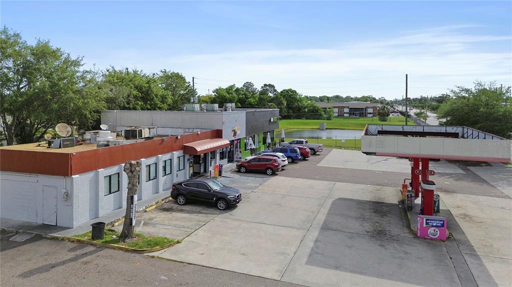 An aerial view shows a commercial building with a gas station canopy and parking lot — 827 W LANCASTER ROAD, ORLANDO, FL