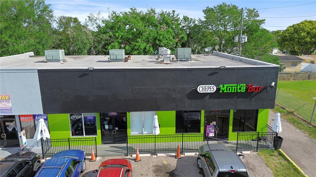 An exterior view of a commercial building with a black facade and green lower walls — 827 W LANCASTER ROAD, ORLANDO, FL