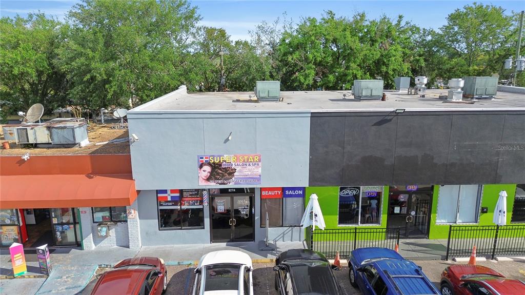 An exterior view of a commercial building featuring a beauty salon and a neighboring storefront — 827 W LANCASTER ROAD, ORLANDO, FL