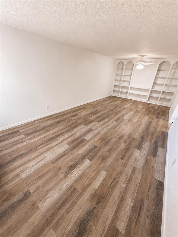 An empty room with wood-look flooring, white walls, and built-in white shelving — 420-420 MILLS STREET UNIT 20, LEESBURG, FL