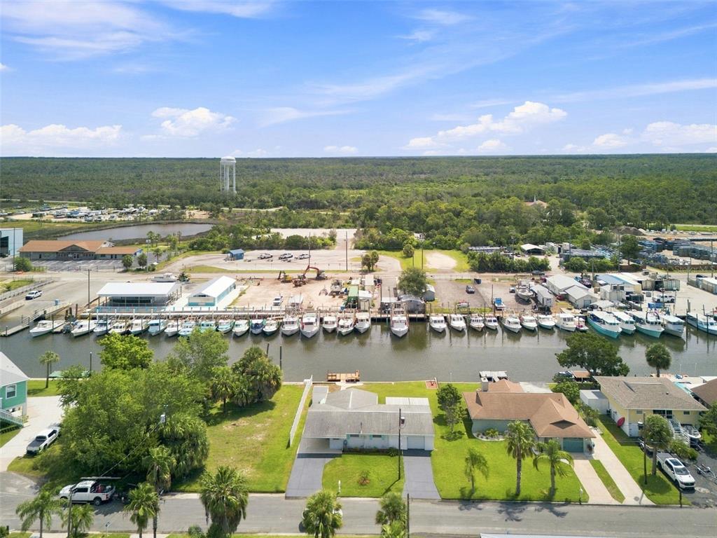 An aerial view shows a residential street with houses facing a canal lined with boats — 4496 BIMINI DRIVE, HERNANDO BEACH, FL