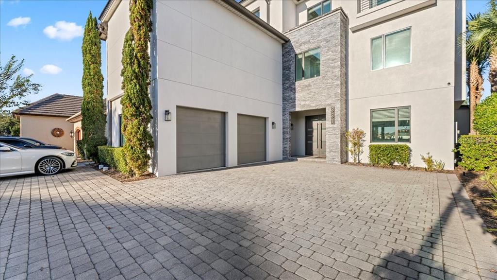 A modern two-story house features a stone facade, a paved driveway, and a two-car garage — 331 MUIRFIELD LOOP, REUNION, FL