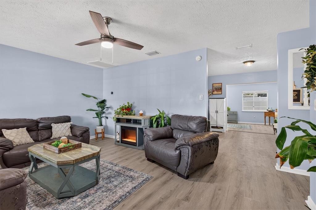 A single-story gray brick house with a metal roof and two large trees in front — 508 COCOPLUM DRIVE, SEFFNER, FL