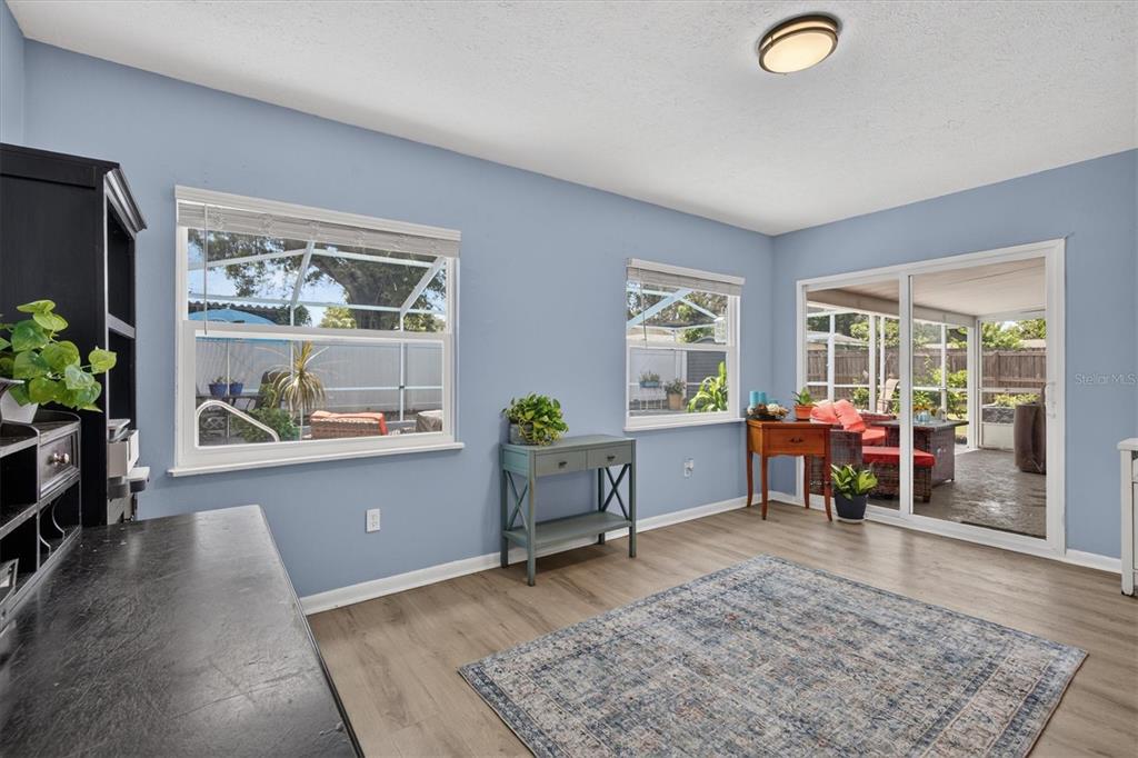 A single-story house with a white brick exterior, metal roof, and a concrete driveway — 508 COCOPLUM DRIVE, SEFFNER, FL