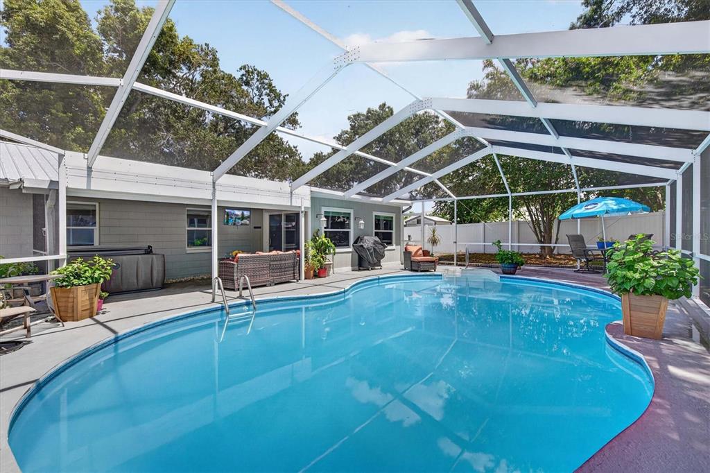 An aerial view shows a house with a metal roof, a screened-in pool, and trees — 508 COCOPLUM DRIVE, SEFFNER, FL