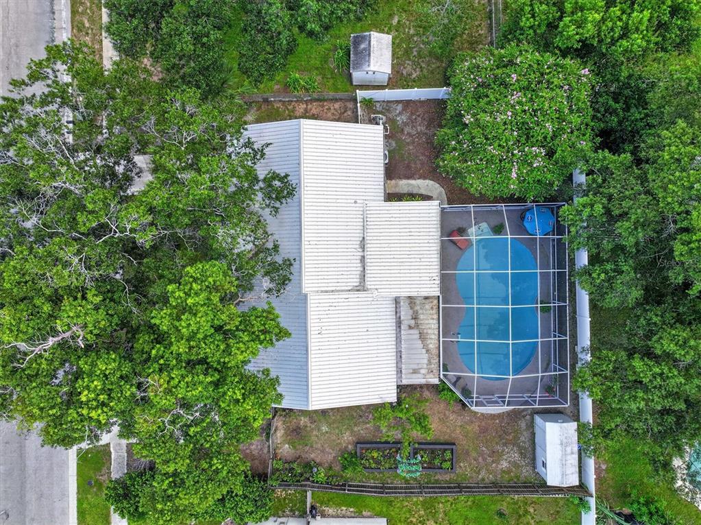 An aerial view shows a house with a metal roof, a screened-in pool, and trees — 508 COCOPLUM DRIVE, SEFFNER, FL