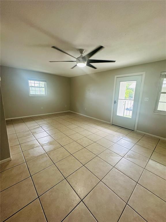 A room with beige tile flooring, a ceiling fan, and a glass-paneled exterior door — 525 CONWAY ROAD UNIT 108, ORLANDO, FL