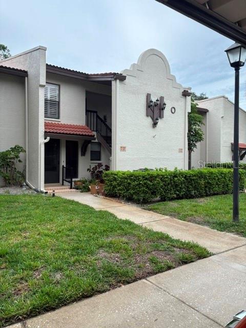 A two-story residential building with a stucco exterior, a red tile roof, and a staircase — 3505 TARPON WOODS BOULEVARD UNIT O-403, PALM HARBOR, FL