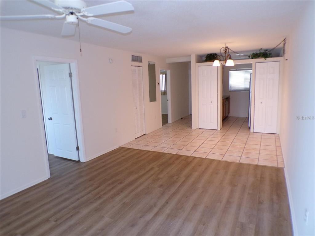 An interior view shows a living area with wood-look flooring and an adjacent tiled kitchen — 649 S TAMIAMI TRAIL S UNIT 304, VENICE, FL
