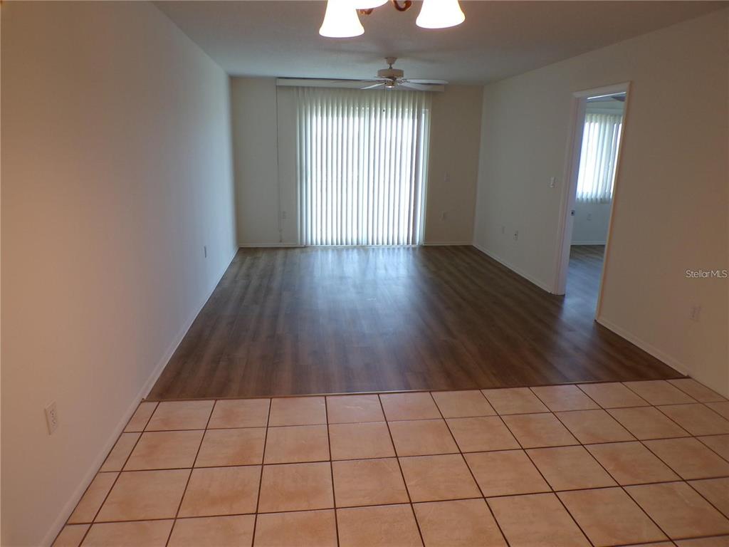 An interior view shows a living area with wood-look flooring and a tiled kitchen floor — 649 S TAMIAMI TRAIL S UNIT 304, VENICE, FL