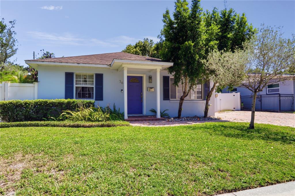 A single-story house with a blue front door, dark shutters, and a paved driveway — 36 E WINTER PARK STREETS, ORLANDO, FL