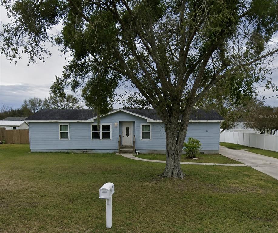 A single-story light blue house with a large tree in the front yard — 4416 MEADOW RIDGE AVENUE, MULBERRY, FL