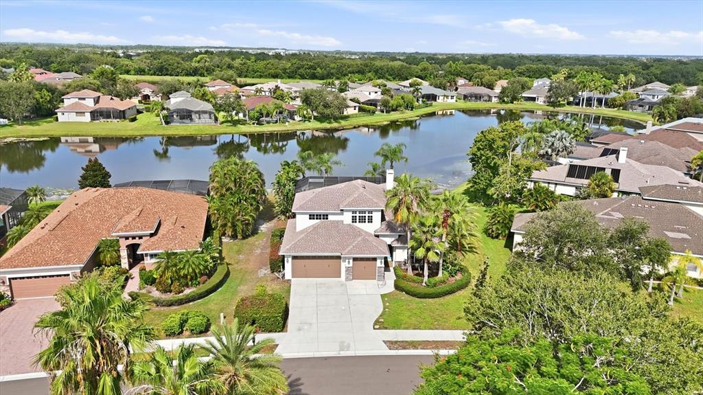 An aerial view shows a two-story suburban house with a lake in the background — 310 SALVIA COURT, BRADENTON, FL