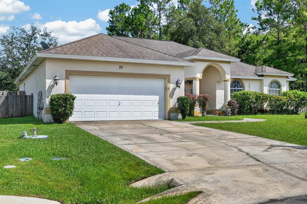 A single-story house with a two-car garage, stucco exterior, and a concrete driveway — 25 KATHRYN PLACE, PALM COAST, FL