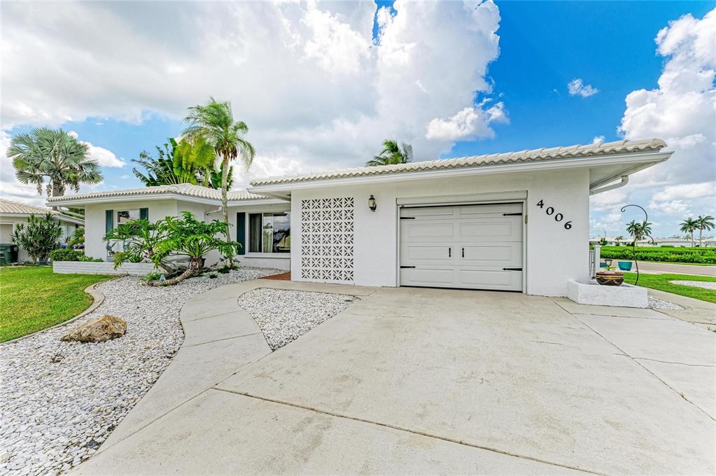 A white single-story house features a concrete driveway, a garage, and decorative breeze block accents — 4006 JOYCE DRIVE, BRADENTON, FL