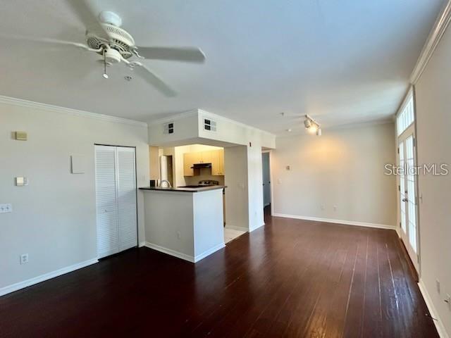 An open-concept living area features dark wood floors, a ceiling fan, and a kitchen island — 770 SIENA PALM DRIVE UNIT 207, CELEBRATION, FL