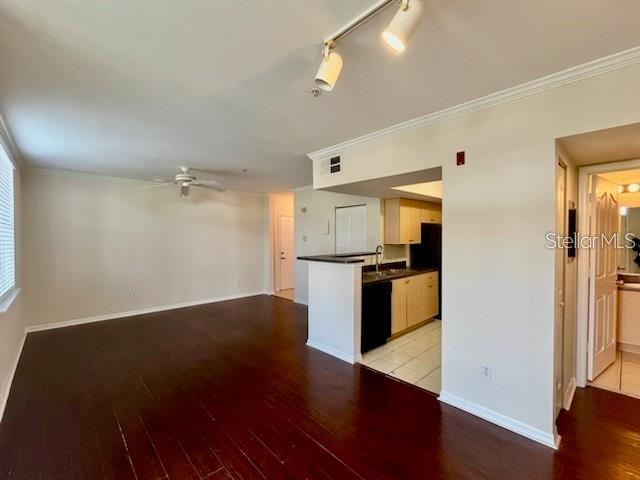 An open living area with dark wood floors leads to a kitchen with light cabinets — 770 SIENA PALM DRIVE UNIT 207, CELEBRATION, FL