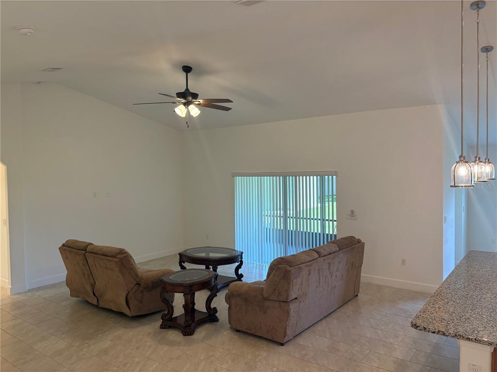 A living room with tile floors, a ceiling fan, and sliding glass doors to outside — 53 ERIC DRIVE, PALM COAST, FL
