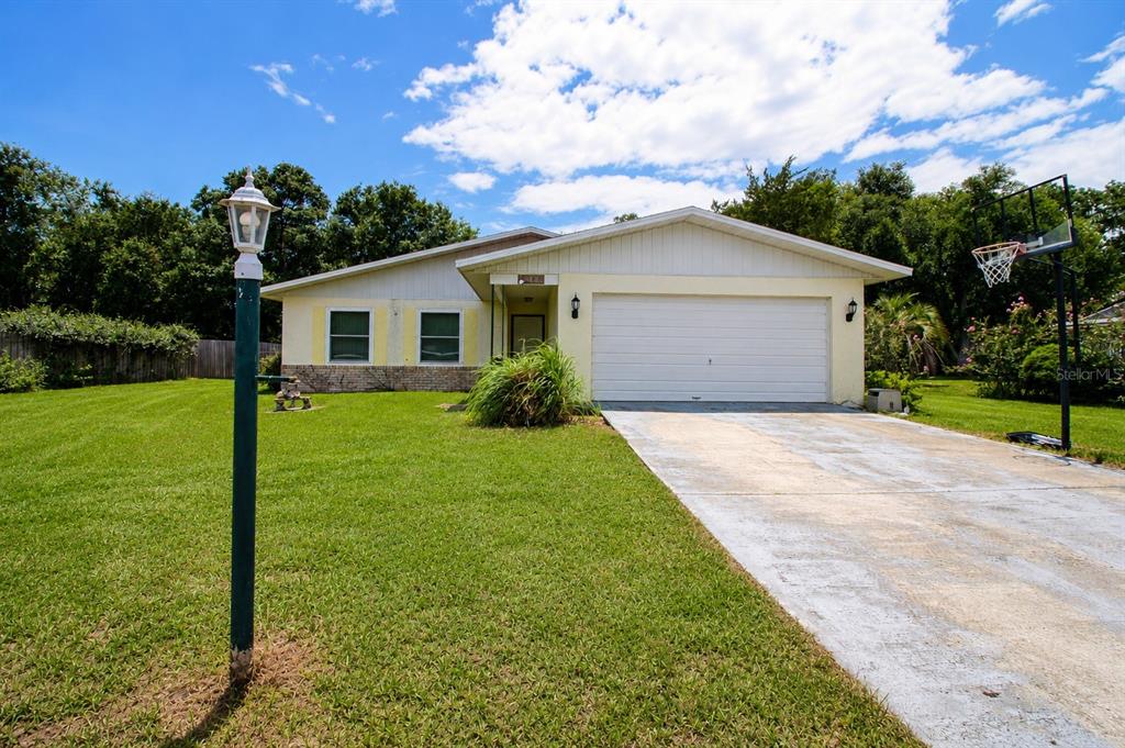A single-story house with a white garage, a concrete driveway, and a grassy front yard — 742 BAHIA CIRCLE, OCALA, FL