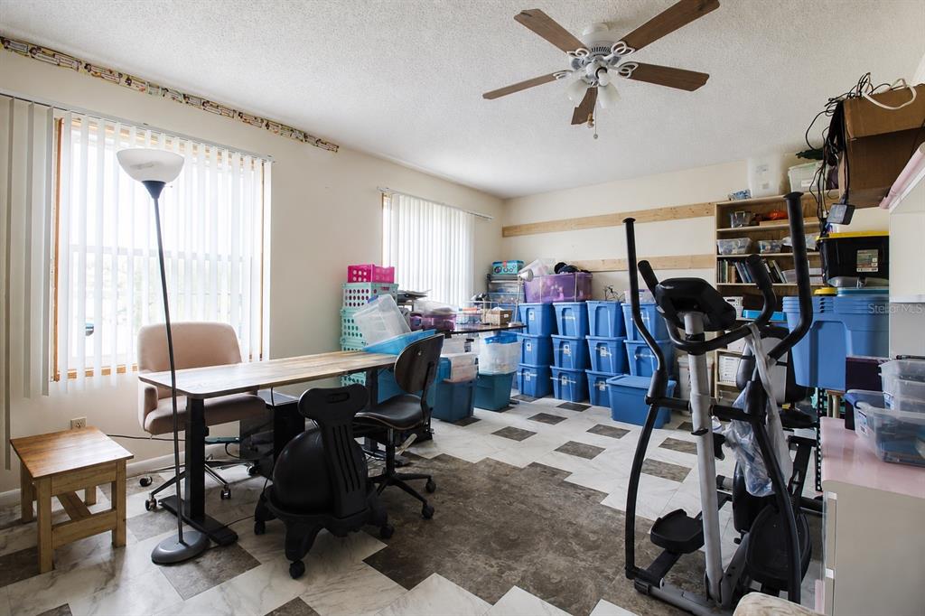 A room with tile flooring, a ceiling fan, a desk, and several storage bins — 742 BAHIA CIRCLE, OCALA, FL