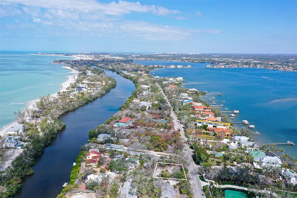 An aerial view shows a vacant lot outlined in white on a narrow coastal peninsula — 8504 HERON LAGOON CIRCLE, SARASOTA, FL
