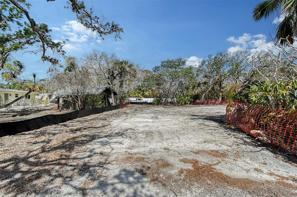 A vacant, cleared residential lot is enclosed by black and orange construction fencing — 8504 HERON LAGOON CIRCLE, SARASOTA, FL