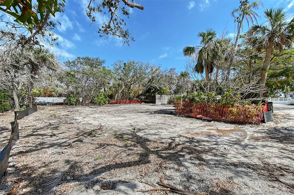 A cleared, sandy residential lot is surrounded by trees and orange construction fencing — 8504 HERON LAGOON CIRCLE, SARASOTA, FL
