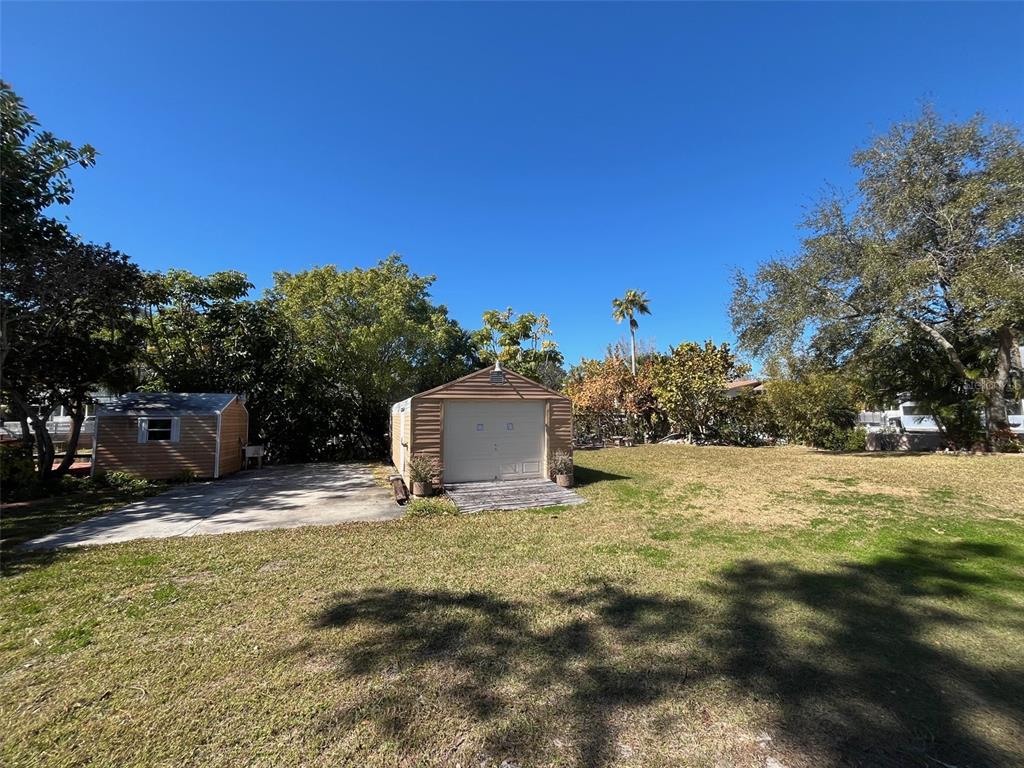 A backyard features a concrete driveway, a small shed, and a detached garage — Lot 96 BLUE JAY CIRCLE, PALM HARBOR, FL