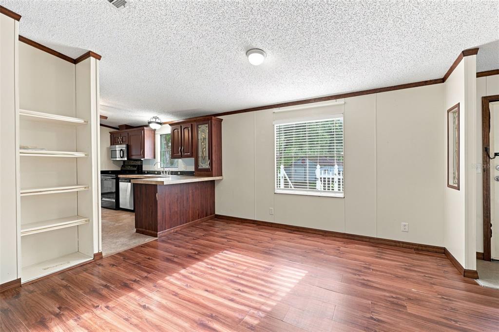 A dining area with wood-look flooring leads to a kitchen with dark wood cabinets — 4311 CULBREATH ROAD, BROOKSVILLE, FL