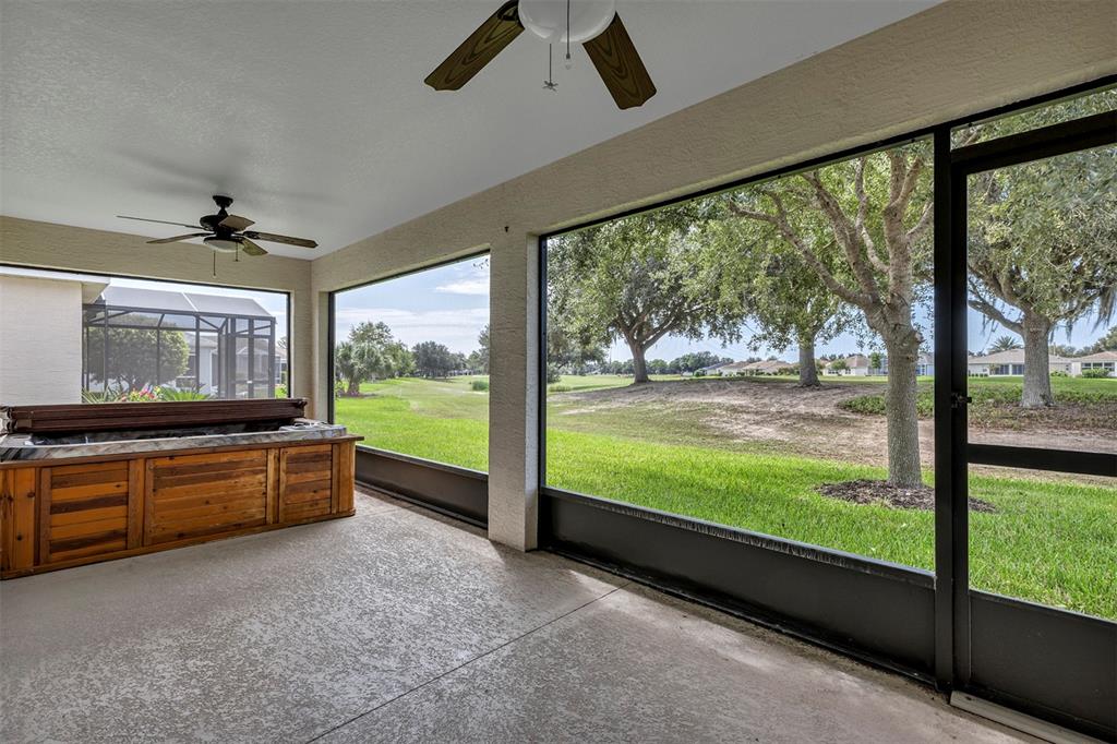 A screened-in patio features a wooden hot tub, two ceiling fans, and a golf course view — 27131 ROANOKE DRIVE, LEESBURG, FL