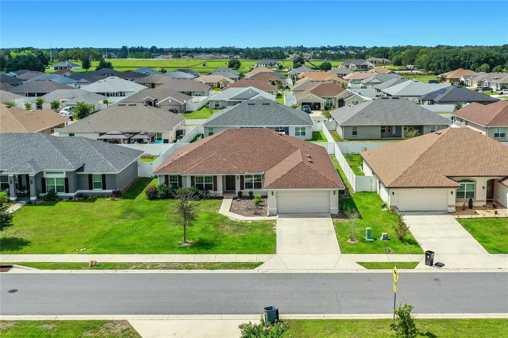 An aerial view shows a suburban house with a brown roof and concrete driveway — 5108 SW 90TH PLACE, OCALA, FL