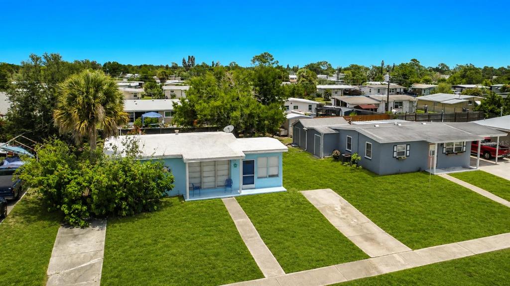 An aerial view shows two adjacent single-story houses with flat roofs and front lawns — 8594 BUMFORD AVENUE, NORTH PORT, FL
