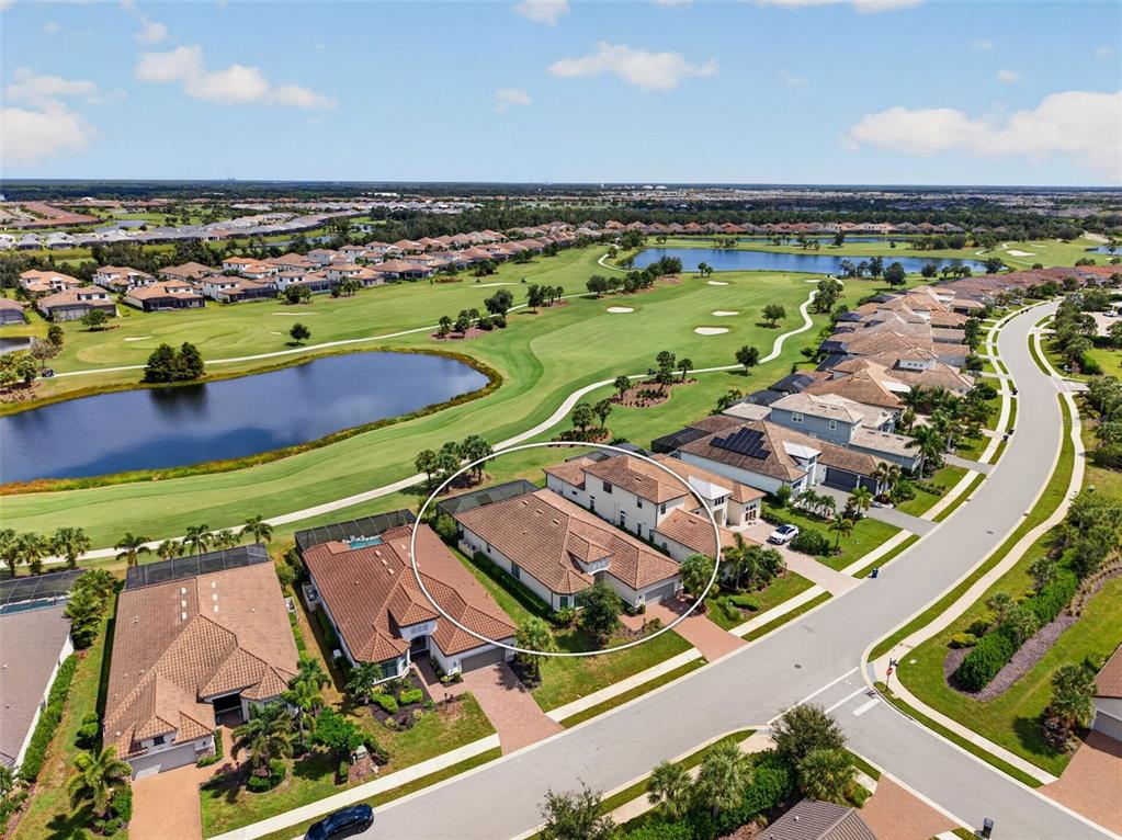 An aerial view shows a residential house with a tiled roof near a golf course — 14833 MONTELLO WAY, BRADENTON, FL