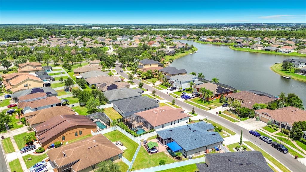 An aerial view of a suburban neighborhood featuring houses with pools near a large lake — 3034 BOATING BOULEVARD, KISSIMMEE, FL
