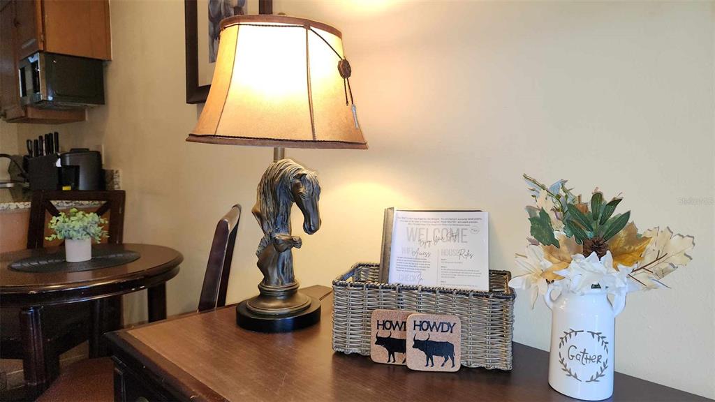 A table lamp with a horse base sits on a wooden surface beside a basket — 3200 RIVER RANCH BOULEVARD UNIT 151, RIVER RANCH, FL