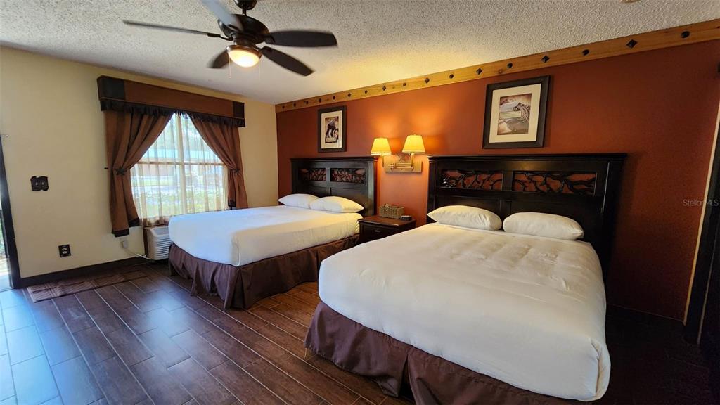 A bedroom features two beds, dark wood furniture, a ceiling fan, and tile flooring — 3200 RIVER RANCH BOULEVARD UNIT 151, RIVER RANCH, FL