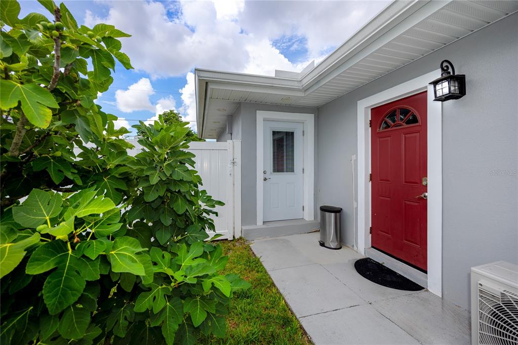 A red front door and a white side door are visible on the exterior wall — 1833 HUNT LANE, CLEARWATER, FL
