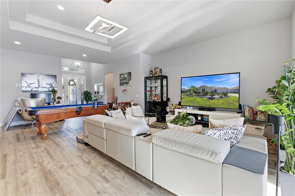 A living room features a pool table, a large sectional sofa, and a wall-mounted television — 35 EDGELY LANE, PALM COAST, FL