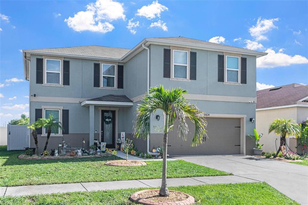 A two-story house with a gray exterior, black shutters, and an attached two-car garage — 10624 ALDO MORO DRIVE, WIMAUMA, FL