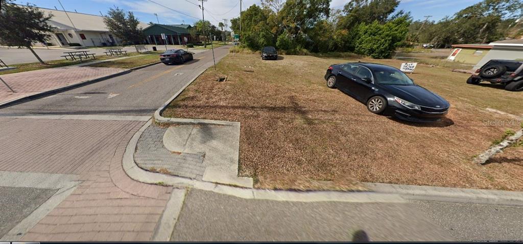 A vacant, grassy corner lot sits adjacent to a paved street and sidewalk — 1400 DR MARTIN LUTHER KING JR WAY, HAINES CITY, FL